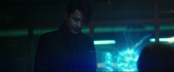 Movie still from “Godzilla vs. Kong” (2021), directed by Adam Wingard – A man standing in a room with a neon light behind him; Medium shot, Low angle