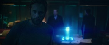 Movie still from “Godzilla vs. Kong” (2021), directed by Adam Wingard – A man standing in front of another man in a dark room; Medium shot, Over the shoulder angle