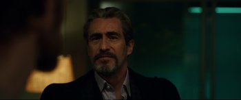 Movie still from “Godzilla vs. Kong” (2021), directed by Adam Wingard – A person wearing a suit and beard; Close Up shot, Over the shoulder angle