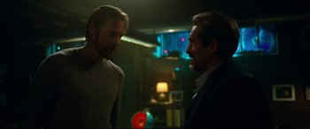 Movie still from “Godzilla vs. Kong” (2021), directed by Adam Wingard – Two men are talking in a room with lights; Medium shot, Over the shoulder angle
