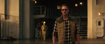 Movie still from “Godzilla vs. Kong” (2021), directed by Adam Wingard – A man wearing a plaid shirt and a vest; Medium shot, Over the shoulder angle