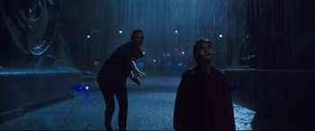 Movie still from “Godzilla vs. Kong” (2021), directed by Adam Wingard – Two people standing in the rain in front of a building; Wide shot, Low angle