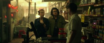 Movie still from “Godzilla vs. Kong” (2021), directed by Adam Wingard – Two people standing at a counter talking to a man; Medium shot, Over the shoulder angle