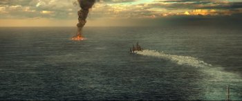 Movie still from “Godzilla vs. Kong” (2021), directed by Adam Wingard – A boat in the ocean with a fire in the background; Extreme Wide shot, High angle