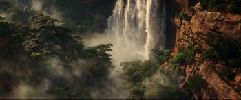 Movie still from “Godzilla vs. Kong” (2021), directed by Adam Wingard – A large waterfall pouring into a valley filled with green trees; Extreme Wide shot, High angle