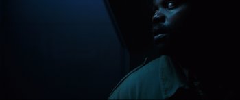 Movie still from “Godzilla vs. Kong” (2021), directed by Adam Wingard – A person in a dark room; Close Up shot, Low angle