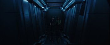 Movie still from “Godzilla vs. Kong” (2021), directed by Adam Wingard – Two people are standing in a dark hallway; Wide shot, Low angle