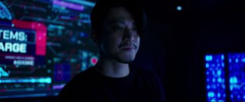 Movie still from “Godzilla vs. Kong” (2021), directed by Adam Wingard – A man in a black shirt is in a dark room; Close Up shot, Low angle