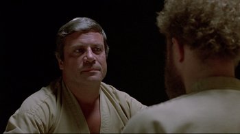 Movie still from “The Brood” (1979), directed by David Cronenberg – An older man looking at himself in the mirror; Close Up shot, Over the shoulder angle