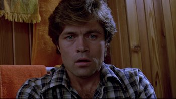 Movie still from “The Brood” (1979), directed by David Cronenberg – A person wearing a plaid shirt; Close Up shot, Low angle