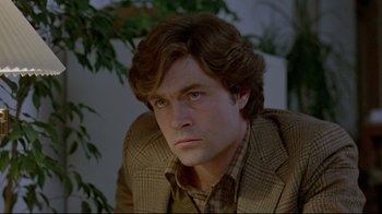 Movie still from “The Brood” (1979), directed by David Cronenberg – A person wearing a suit and tie; Close Up shot, Over the shoulder angle