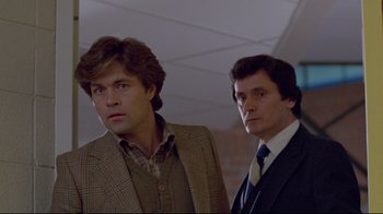 Movie still from “The Brood” (1979), directed by David Cronenberg – Two men standing next to each other wearing suits and ties; Medium shot, Low angle