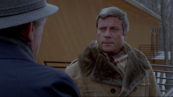 Movie still from “The Brood” (1979), directed by David Cronenberg – A man wearing a fur coat and a hat; Close Up shot, Over the shoulder angle