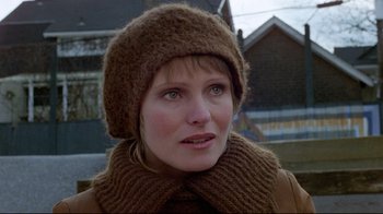 Movie still from “The Brood” (1979), directed by David Cronenberg – A person wearing a hat and a scarf; Close Up shot, Over the shoulder angle