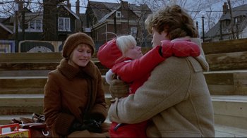 Movie still from “The Brood” (1979), directed by David Cronenberg – Two women and a baby are sitting on a bench; Medium shot, Over the shoulder angle