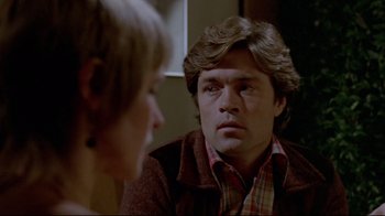Movie still from “The Brood” (1979), directed by David Cronenberg – A man and a woman sitting in front of each other in a room; Close Up shot, Over the shoulder angle