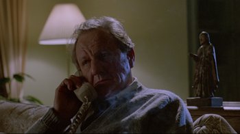 Movie still from “The Brood” (1979), directed by David Cronenberg – An older man talking on a phone while sitting in a chair; Close Up shot, Low angle