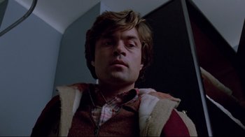 Movie still from “The Brood” (1979), directed by David Cronenberg – A person wearing a vest; Close Up shot, Low angle