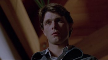 Movie still from “The Brood” (1979), directed by David Cronenberg – A young man looking up into the air; Close Up shot, Low angle