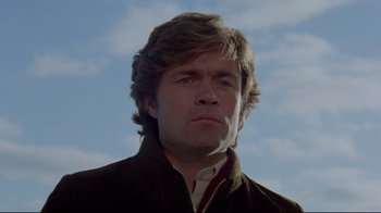 Movie still from “The Brood” (1979), directed by David Cronenberg – A person wearing a jacket with a sky in the background; Close Up shot, Low angle