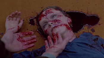 Movie still from “The Brood” (1979), directed by David Cronenberg – A man with blood all over his face and hands; Close Up shot, Overhead angle
