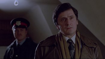 Movie still from “The Brood” (1979), directed by David Cronenberg – A man in a brown jacket and a tie; Close Up shot, Low angle