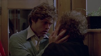 Movie still from “The Brood” (1979), directed by David Cronenberg – A man holding a woman's head while looking at him; Close Up shot, Over the shoulder angle