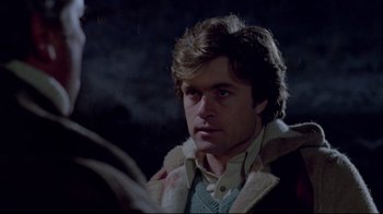 Movie still from “The Brood” (1979), directed by David Cronenberg – A young man reading a book in a dark room; Close Up shot, Over the shoulder angle