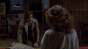 Movie still from “The Brood” (1979), directed by David Cronenberg – A man and a woman looking at each other in a mirror; Medium shot, Over the shoulder angle