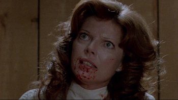 Movie still from “The Brood” (1979), directed by David Cronenberg – A person with blood all over their face; Close Up shot, Over the shoulder angle