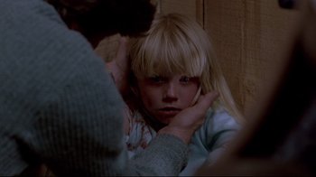 Movie still from “The Brood” (1979), directed by David Cronenberg – A young girl with her hand on her head; Close Up shot, High angle