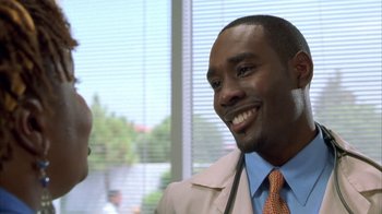Movie still from “The Brothers” (2001), directed by Gary Hardwick – A man wearing a suit and tie smiling for the camera; Close Up shot, Over the shoulder angle