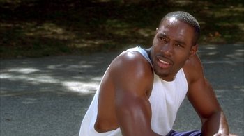 Movie still from “The Brothers” (2001), directed by Gary Hardwick – A person sitting on the ground near a tree; Close Up shot, High angle