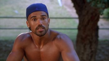 Movie still from “The Brothers” (2001), directed by Gary Hardwick – A shirtless man with a blue hat and ear buds; Close Up shot, High angle
