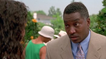 Movie still from “The Brothers” (2001), directed by Gary Hardwick – A man in a tan suit and a woman in a white hat; Close Up shot, Over the shoulder angle