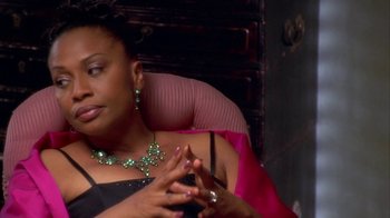 Movie still from “The Brothers” (2001), directed by Gary Hardwick – A woman sitting in a chair wearing a necklace and earrings; Close Up shot, High angle