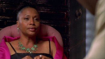 Movie still from “The Brothers” (2001), directed by Gary Hardwick – A woman sitting in a chair wearing a green necklace; Close Up shot, High angle