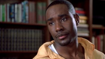 Movie still from “The Brothers” (2001), directed by Gary Hardwick – A person with a book shelf in the background; Close Up shot, High angle