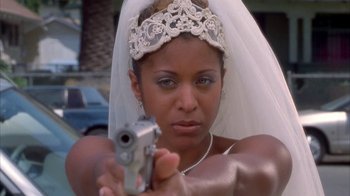 Movie still from “The Brothers” (2001), directed by Gary Hardwick – A woman wearing a veil and holding a gun; Close Up shot, High angle
