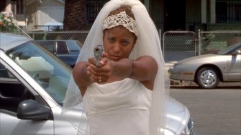 Movie still from “The Brothers” (2001), directed by Gary Hardwick – A woman in a wedding dress and veil holding a gun; Medium shot, High angle