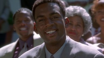 Movie still from “The Brothers” (2001), directed by Gary Hardwick – A person wearing a suit and smiling; Close Up shot, Low angle