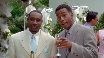 Movie still from “The Brothers” (2001), directed by Gary Hardwick – A couple of men standing next to each other holding champagne; Medium shot, High angle