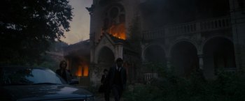 Movie still from “The Brothers Bloom” (2008), directed by Rian Johnson – Two men walking in front of a burning building; Extreme Wide shot, Low angle