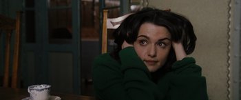 Movie still from “The Brothers Bloom” (2008), directed by Rian Johnson – A person sitting at a table; Close Up shot, High angle