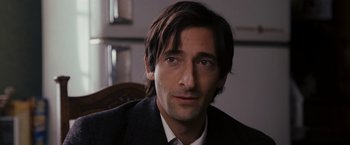 Movie still from “The Brothers Bloom” (2008), directed by Rian Johnson – A person wearing a suit and tie; Close Up shot, Over the shoulder angle