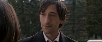 Movie still from “The Brothers Bloom” (2008), directed by Rian Johnson – A person wearing a suit and tie; Close Up shot, Over the shoulder angle