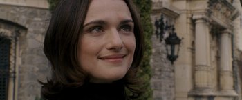 Movie still from “The Brothers Bloom” (2008), directed by Rian Johnson – A woman's face in front of a building; Close Up shot, Over the shoulder angle
