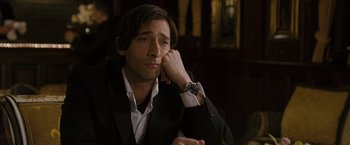 Movie still from “The Brothers Bloom” (2008), directed by Rian Johnson – A person wearing a suit and tie; Close Up shot, Over the shoulder angle
