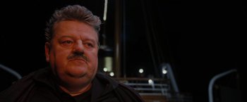 Movie still from “The Brothers Bloom” (2008), directed by Rian Johnson – A person wearing a black shirt; Close Up shot, Low angle