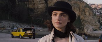 Movie still from “The Brothers Bloom” (2008), directed by Rian Johnson – A person wearing a hat; Close Up shot, Over the shoulder angle